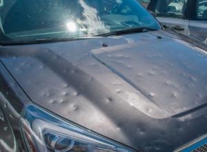 hood of car with dents after a hail storm